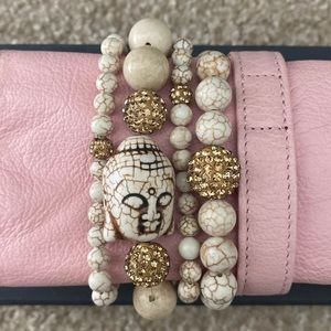 Set of four stackable bracelets, cream with gold accents.